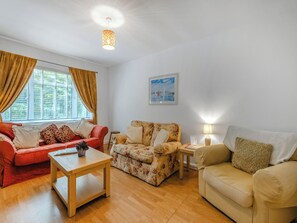 Una sala de estar con sofá, sillón y una mesa.