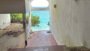 Eine Betontreppe führt zu einem Blick auf den Strand durch ein Fenster.