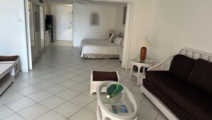 Ein Hotelzimmer mit einem Bett, einer Couch, einem kleinen Tisch mit Lampe und einem Sessel.
