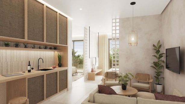 A modern living room with a sofa, a coffee table, and a TV mounted on the wall. There is a kitchen area with a sink and a dining table. - Açai Plant based Hotel (Rhodes)