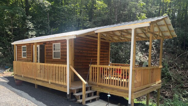 A wooden cabin with a porch and a covered deck area. -  Tiny Cabin in the Laurels, with queen bed & queen sofa bed in wooded setting. (Marion)
