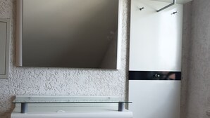 A compact room with a white cabinet, a mirror, and a small wooden chair. - Beautiful apartment in central Ingoöstadt (Ingolstadt)