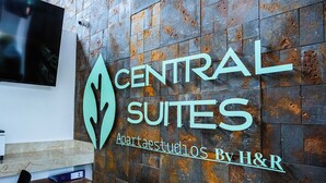 A sign for Central Suites by H&R, featuring a modern design with a leaf motif. - Central Suites by H&R (Villeta)