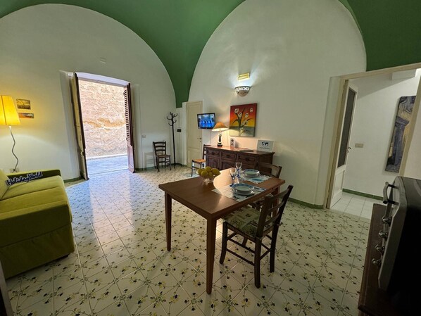 Enjoy meals in the dining area with a table and chairs, a TV on the wall, and a painting above.