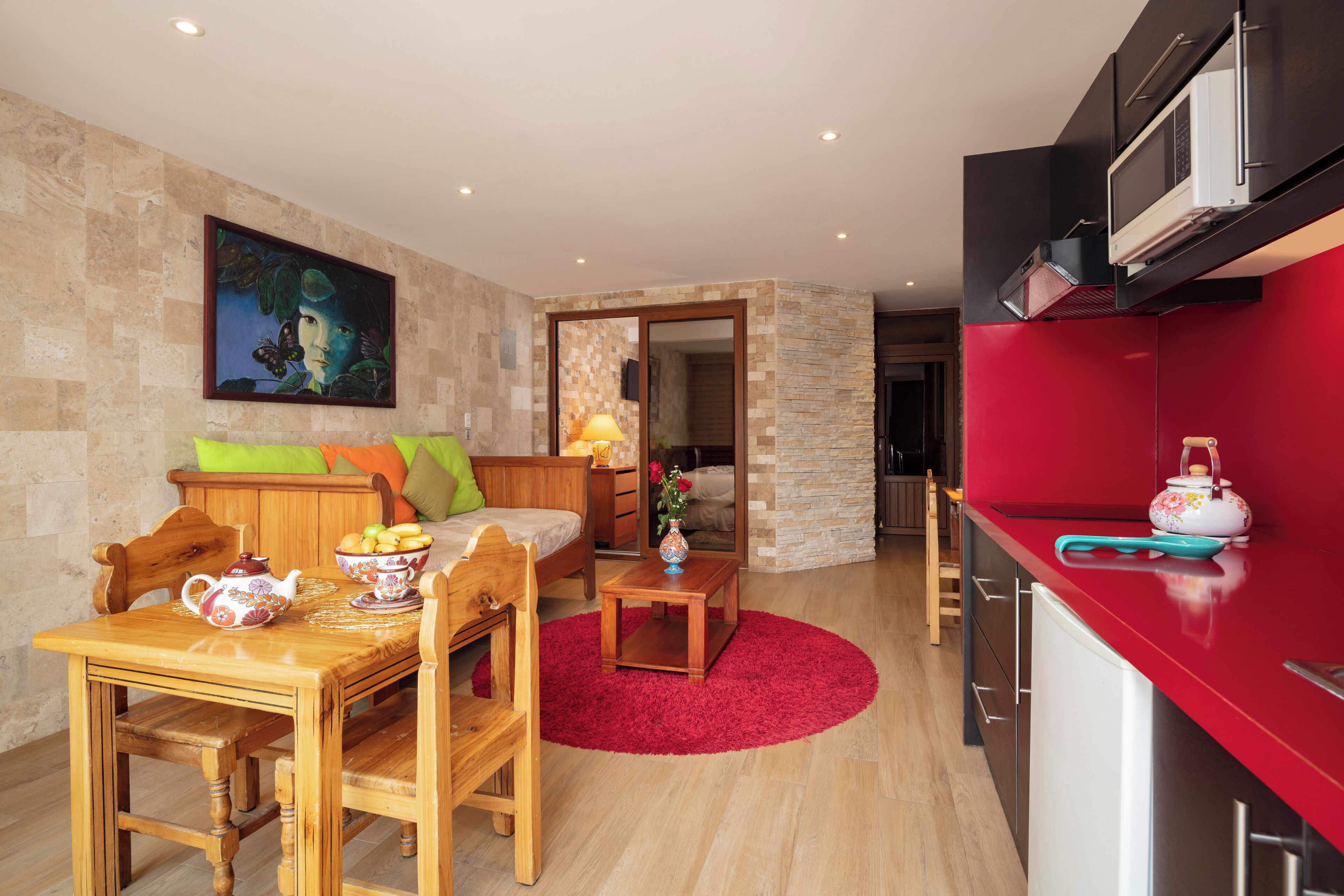A compact living space with a dining area, a kitchen, and a bedroom.