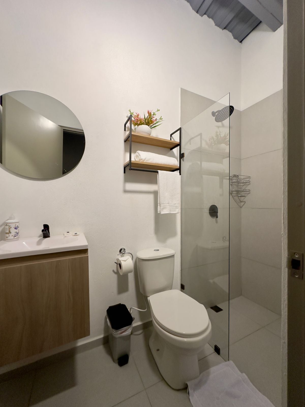 Un baño moderno con inodoro, lavamanos y ducha.