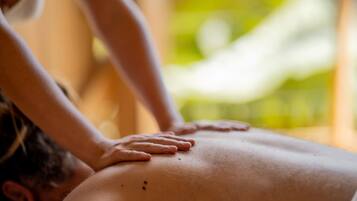A massage therapy session with a focus on the therapist's hands on a client's back.