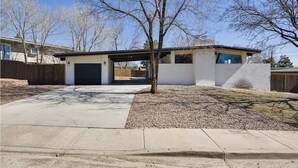 A modern single-story house with a garage, a covered driveway, and a small tree in the front yard. - Hidden Jewel for the Family, Near the Broadmoor (Colorado Springs)