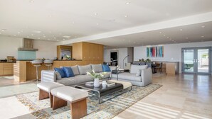 A spacious living area with a sofa, coffee table, and a dining area with chairs. - Jewel by Avantstay Panoramic Ocean Views in La Jolla! (La Jolla)