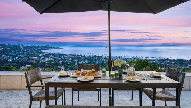 A table set for breakfast with a view of the ocean and cityscape. - Jewel by Avantstay Panoramic Ocean Views in La Jolla! (La Jolla)