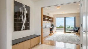 A modern interior with a large artwork, a kitchen area, a seating area with a view, and a sliding glass door leading to an outdoor space. - Jewel by Avantstay Panoramic Ocean Views in La Jolla! (La Jolla)