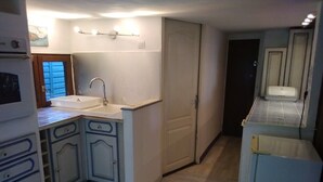 A compact kitchen with a sink, cabinets, and a refrigerator. - Maison six Couchages à Proximité de la Mer. Location Aout, Septembre 2024 (Le Castellet)