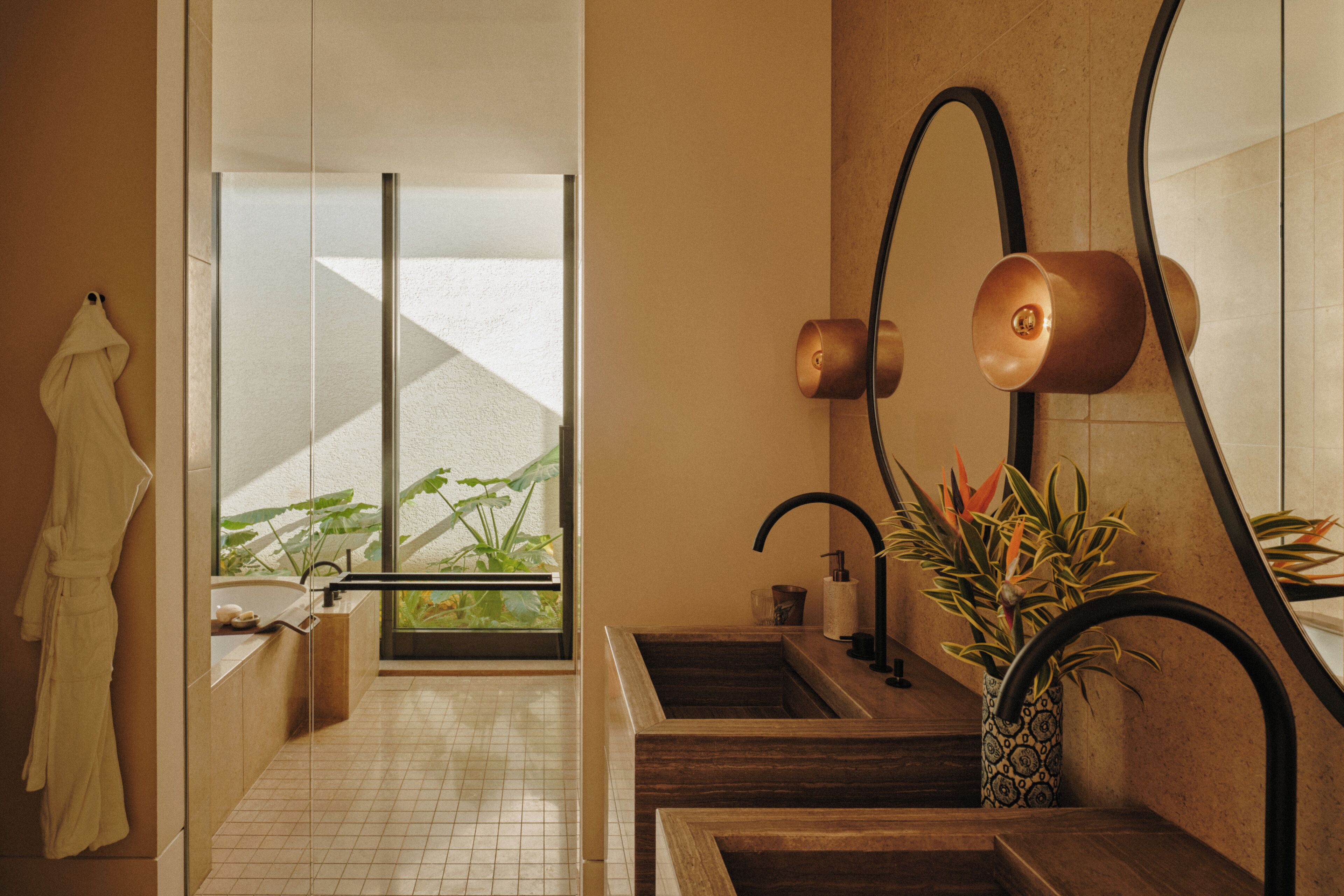 A modern bathroom with a glass shower enclosure, a wooden vanity, and a large mirror.