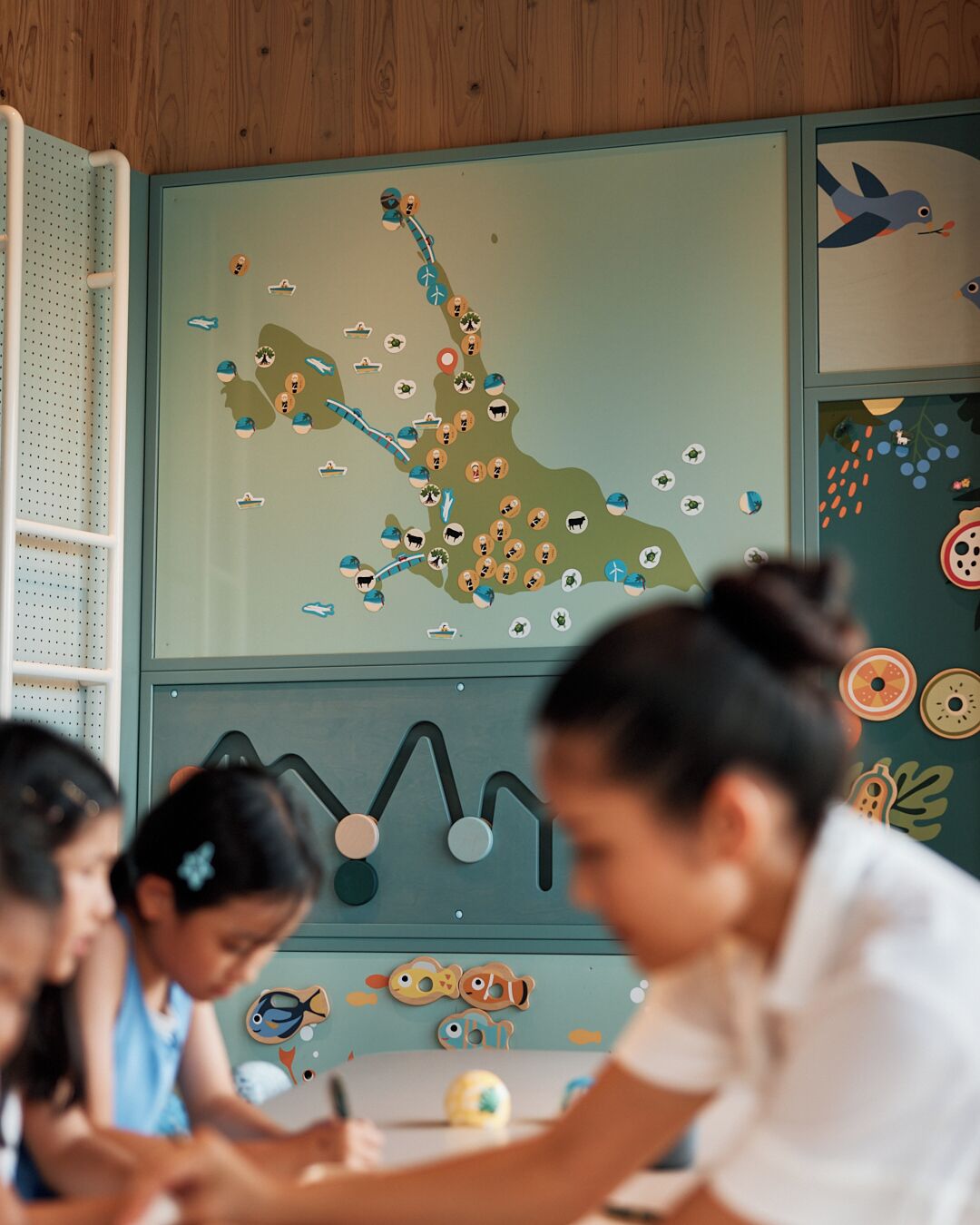 A classroom with educational posters on the walls, a whiteboard, and students engaged in a learning activity.