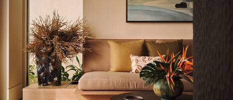 A modern living room with a sofa, a round coffee table, and decorative plants.