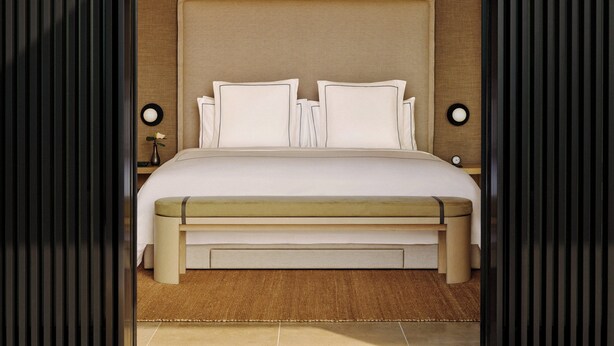 Una habitación de hotel moderna con una cama grande, una mesita de noche y un tocador.
