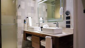 Une salle de bain moderne avec deux lavabos, un grand miroir et un espace douche.