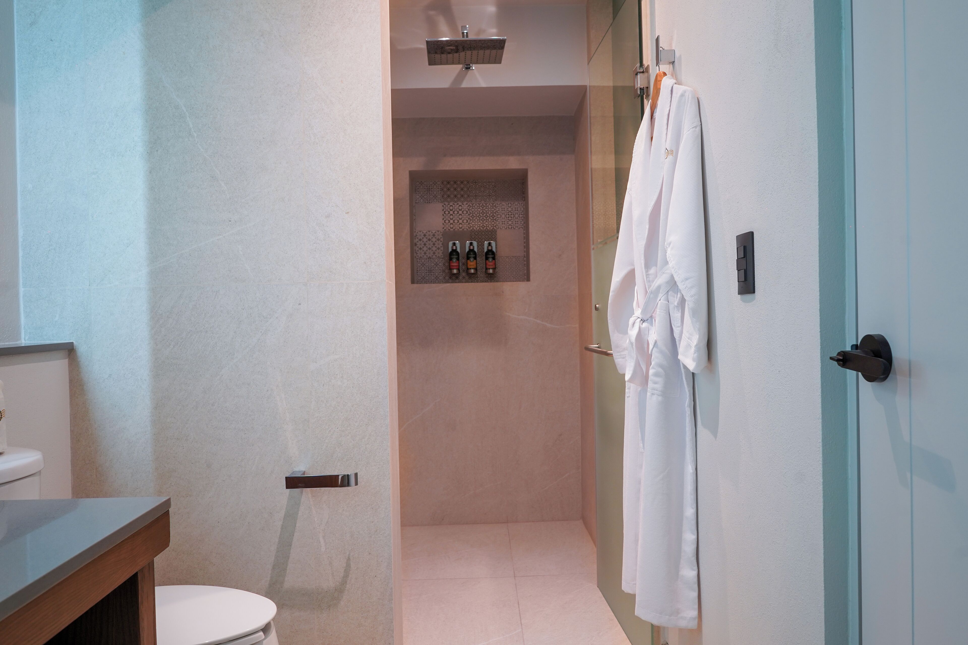 A modern bathroom with a toilet, a shower area, and a towel rack.