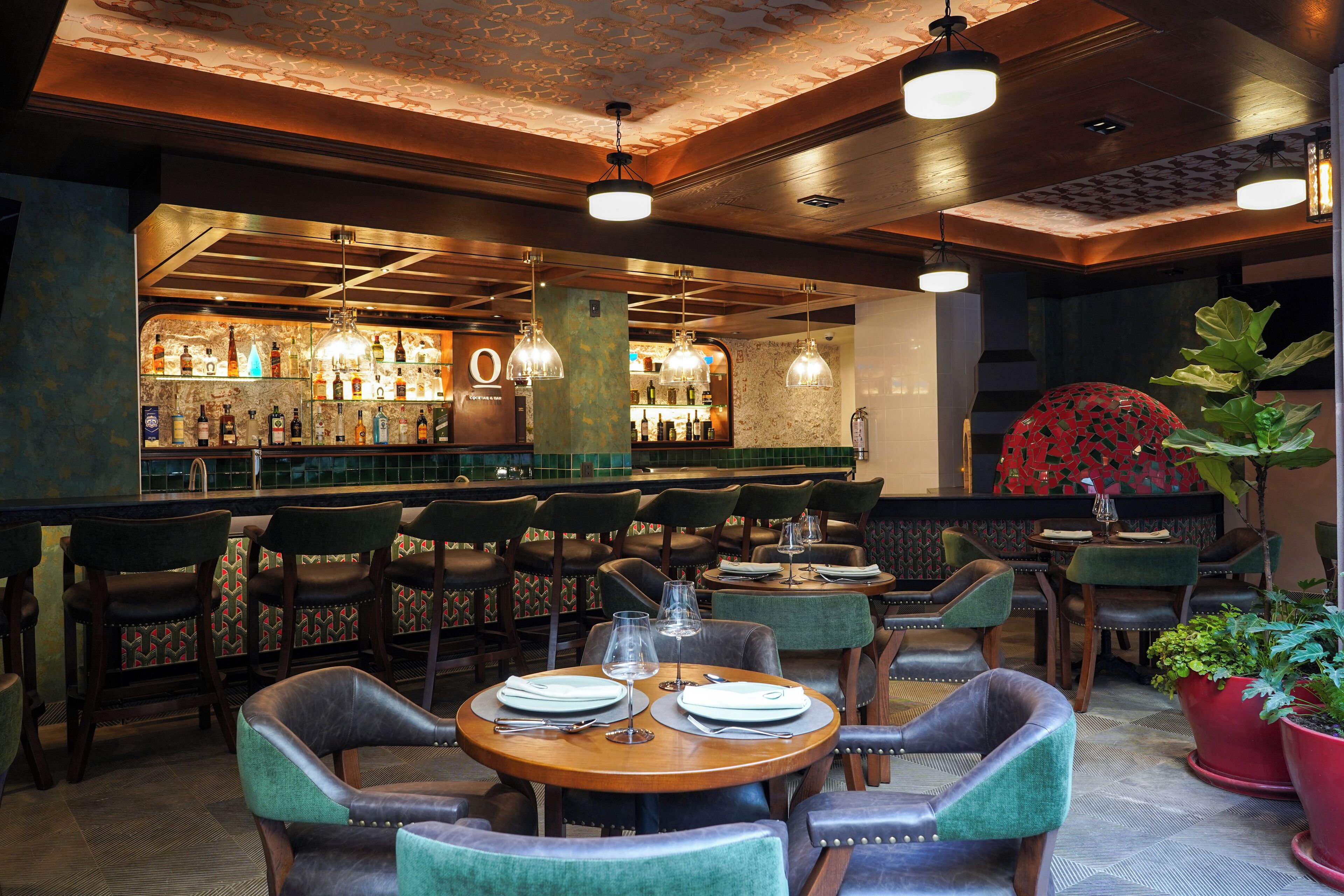 Ein Restaurant mit Barbereich, Holztischen und -stühlen.
