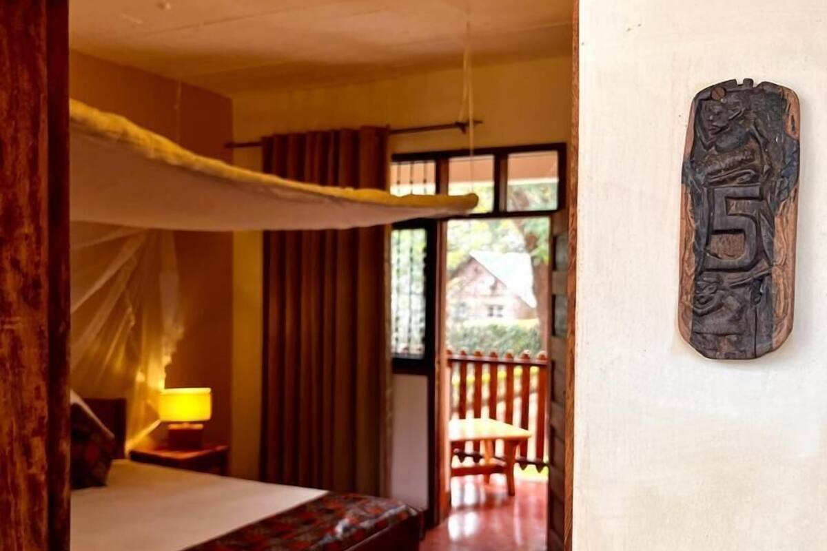 A bedroom with a bed, a bedside lamp, and a wooden headboard.