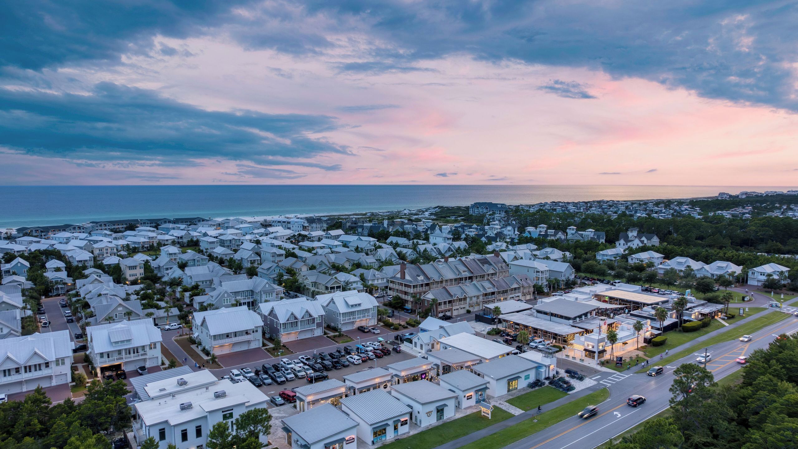 Un quartier résidentiel situé sur la côte, avec des maisons, une route et une vue sur l’océan.