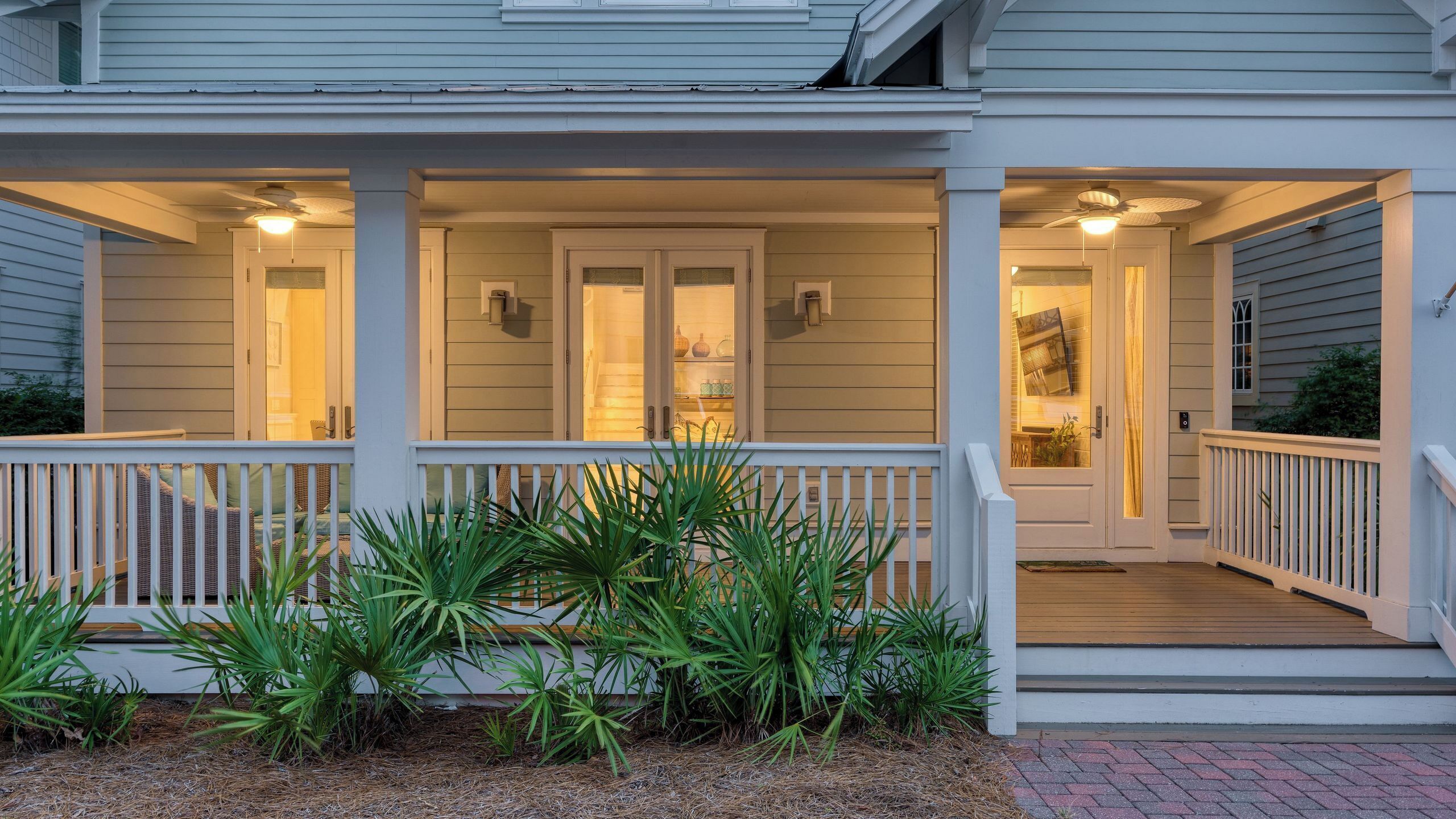 A house with a porch, two doors, and a staircase leading to the entrance.