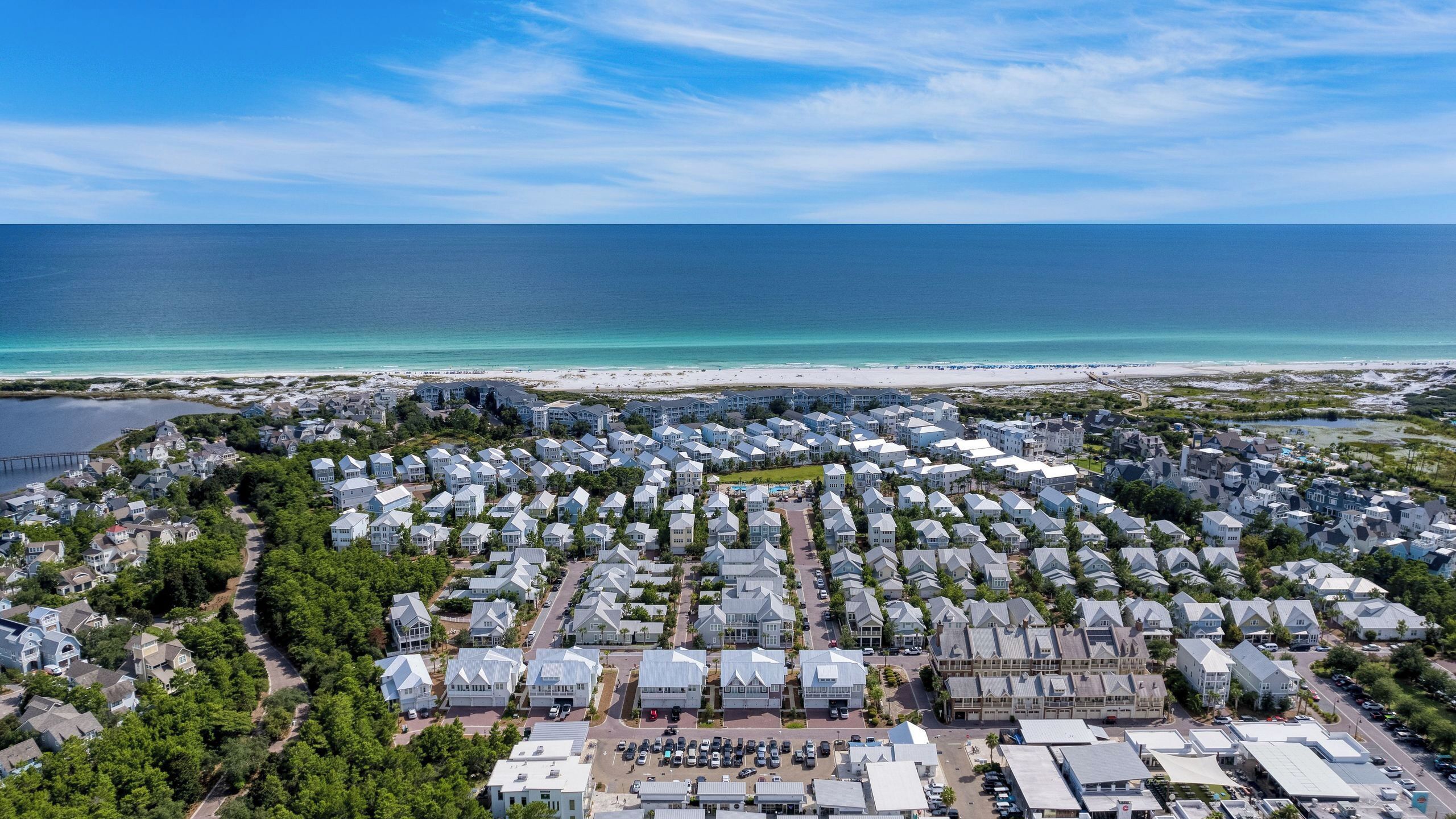 A coastal residential area with multiple houses, a beach, and a clear view of the ocean.