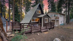 A cabin with a steep roof, a deck, and a fenced area with a table and chairs. - Speckled by Avantstay Modern Interior, 0.5mi to Lake! (Kings Beach)