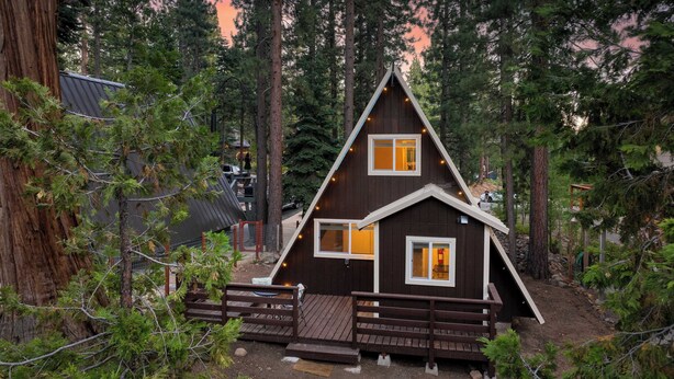 A cabin with a triangular roof, wooden deck, and a small porch. - Speckled by Avantstay Modern Interior, 0.5mi to Lake! (Kings Beach)