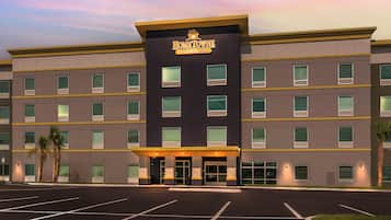 A multi-story hotel with a prominent entrance and a parking lot in front.