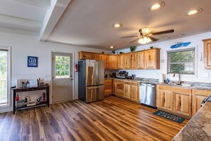 A modern kitchen with wooden cabinets, stainless steel appliances, and a granite countertop. - Lakefront Retreat w/Pvt Dock, Game Room, Hot Tub (Murray)