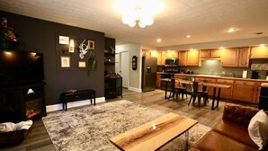 A modern living room with a fireplace, a wooden coffee table, and a brown leather sofa. -  The Lounge - Downtown Chillicothe (Chillicothe)