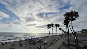 A beachside promenade with palm trees, a road, and beachgoers. - OCEANSIDE BEACH HOUSE~Dreamy Palm Tree Lined Street~5 MIN WALK to EVERYTHING!  (Oceanside)