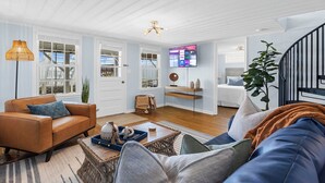 A living room with a sofa, a coffee table, and a TV mounted on the wall. - SY Oceanfront-Heated Pool-Bar-firepit-horseshoe (North Myrtle Beach)