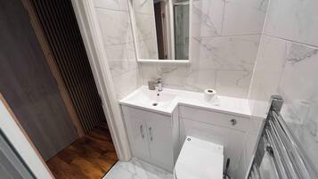 Deluxe Studio Suite | Bathroom | Shower, towels, soap, shampoo