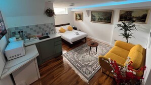 A compact bedroom with a bed, bedside table, and a small round table. - Haven Homes (Luton)