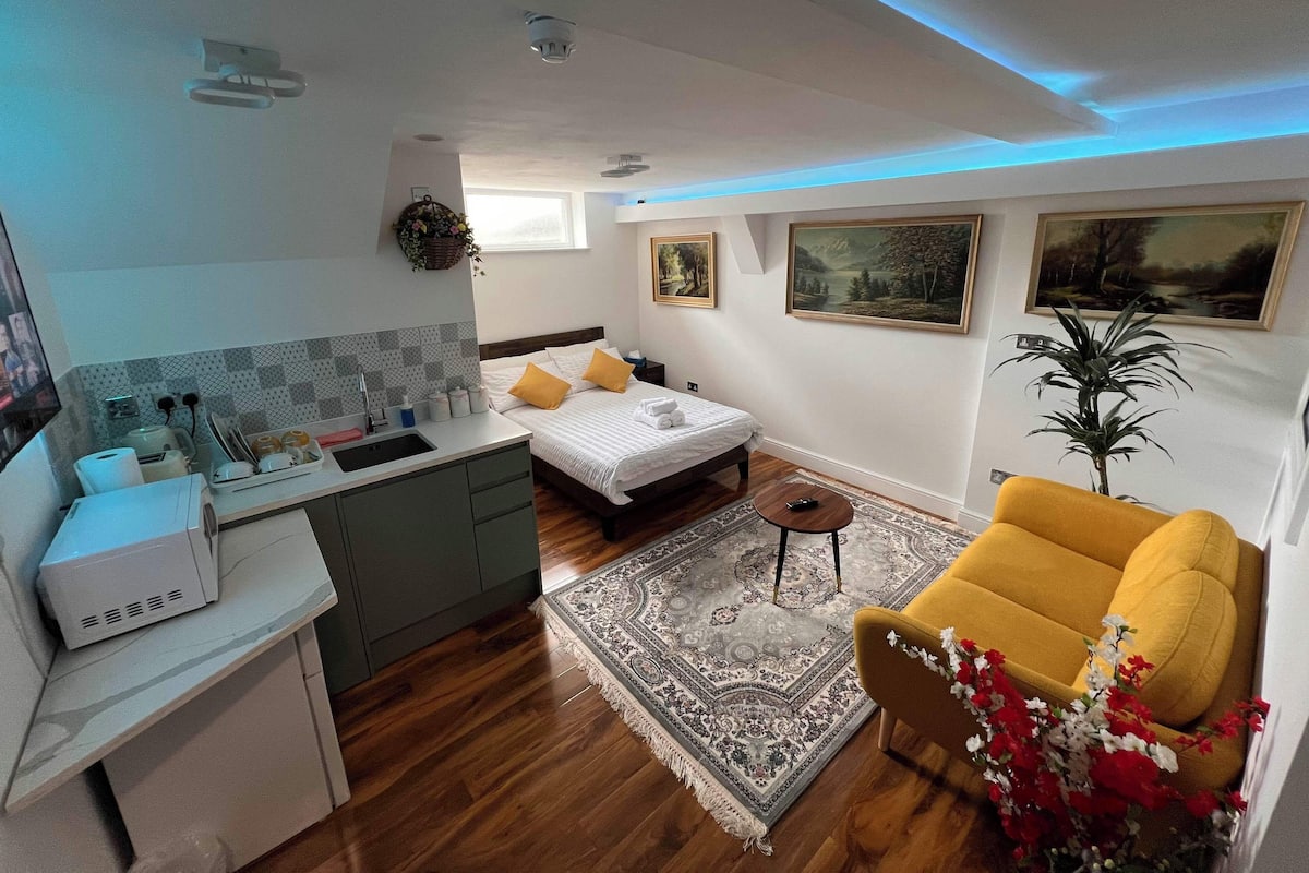 A compact bedroom with a bed, bedside table, and a small round table.