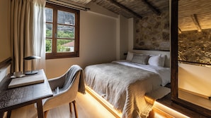 Een slaapkamer met een bed, een bureau, een stoel en een raam met gordijnen.