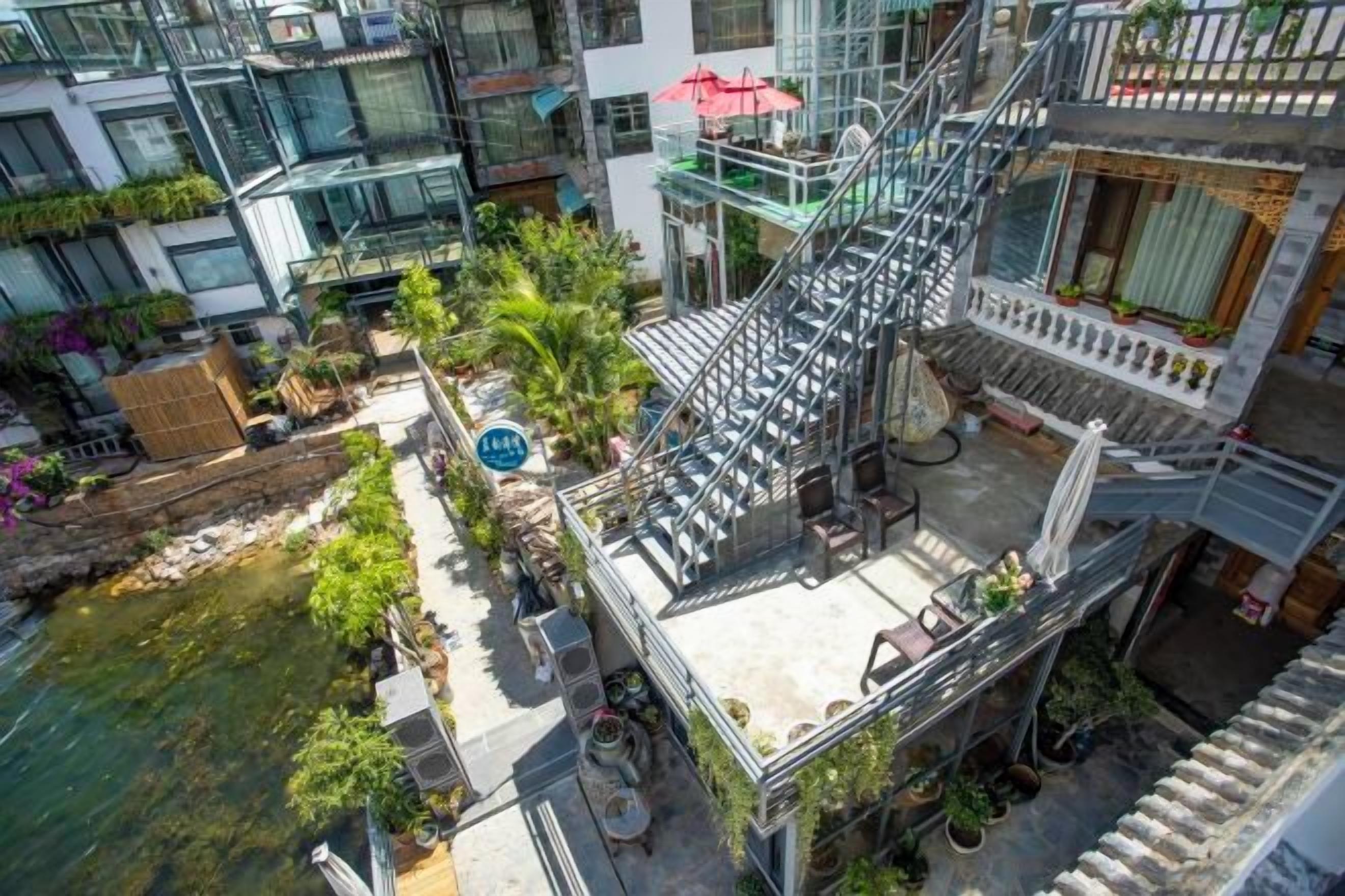 A multi-story building with a rooftop garden, outdoor seating area, and a staircase leading to the upper floors.