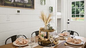 A dining table set with plates, glasses, and a centerpiece. - Newly Built Home in Pigeon Forge (Pigeon Forge)