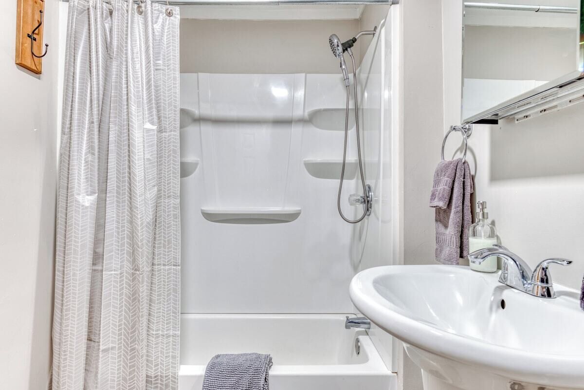 Une salle de bain moderne équipée d’une douche, d’une baignoire et d’un lavabo.