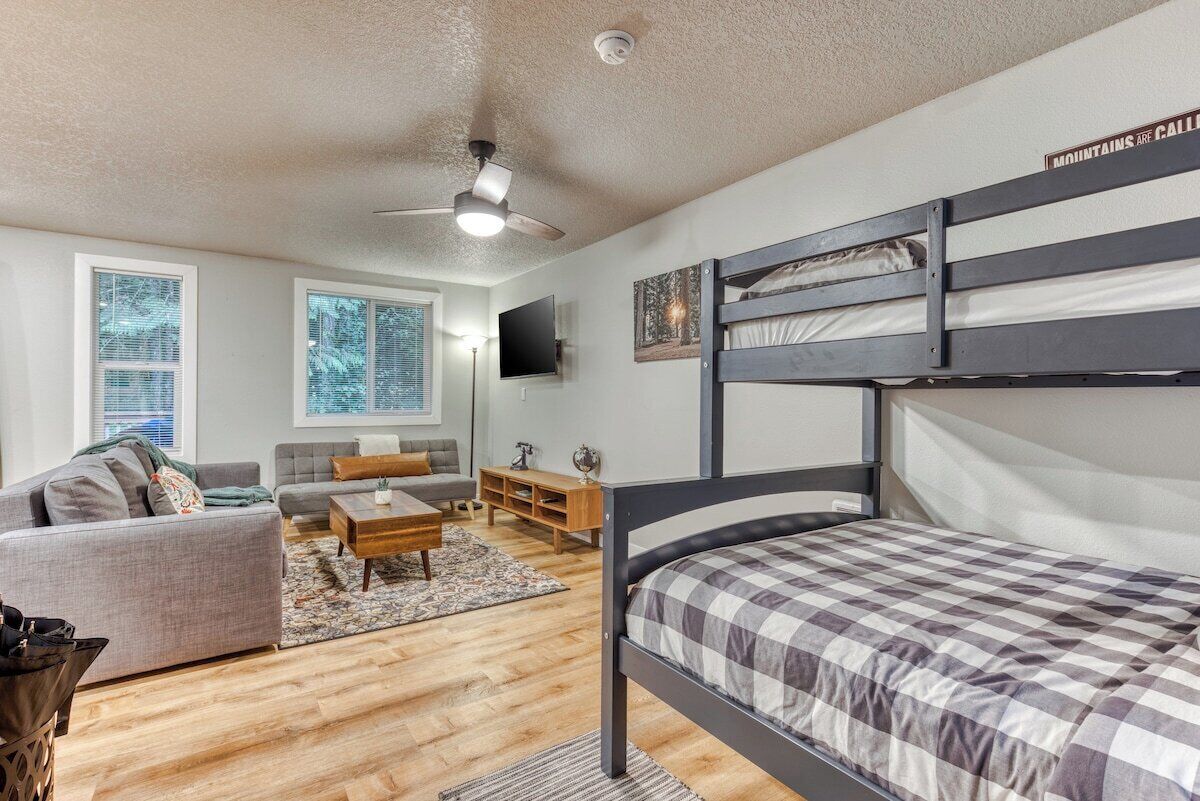 A compact living space with a bunk bed, a sofa, a coffee table, and a television.
