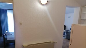 A hotel room with a bed, a heater, a small table, and a sofa. - Apartments Libertas - One Bedroom Apartment with Terrace and Sea View - (5) (Rogoznica)