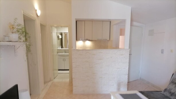 Un apartamento moderno con sala de estar, kitchenette y baño.