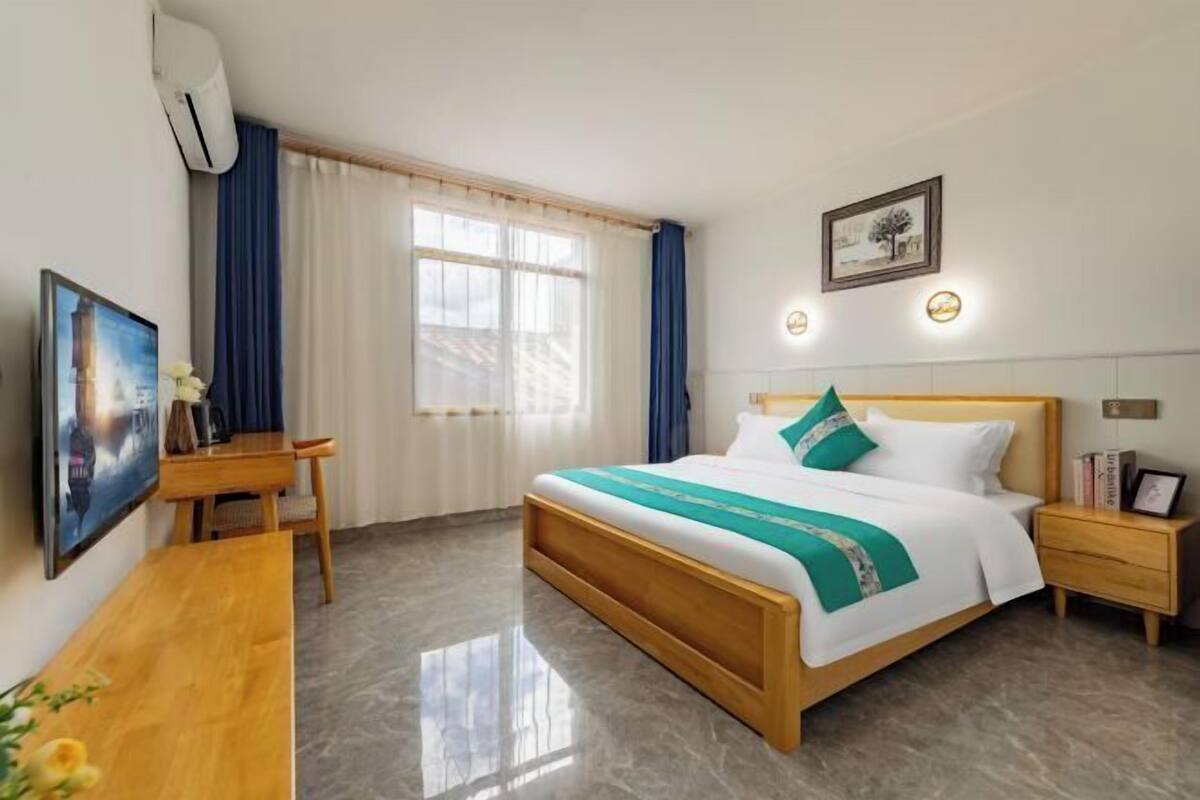 Une chambre d’hôtel comprenant un lit, des tables de chevet, un bureau et une chaise.