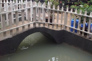 Uma ponte de piquetes brancos sobre a água.