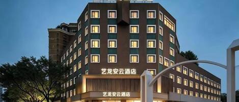 Un hôtel à plusieurs étages, doté d’un design moderne, avec une entrée imposante et une structure incurvée sur le côté droit.