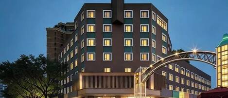 A multi-story hotel with a prominent entrance, a covered walkway, and a modern architectural design.