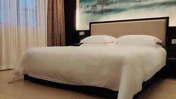 Una cama bien hecha con una colcha blanca en una habitación de hotel.