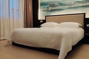 Ein ordentlich bezogenes Bett mit weißer Bettdecke in einem Hotelzimmer.